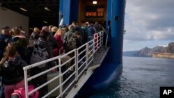 Passengers board a ferry to Athens' port of Piraeus after a spike in seismic activity raised concerns about a potentially powerful earthquake in Santorini, southern Greece, Feb. 3, 2025.