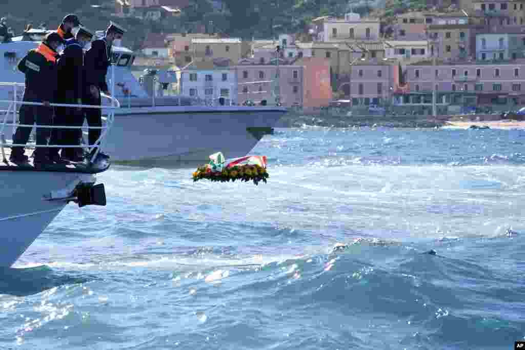A flower wreath is set out to sea during a commemoration for the the victims of the Costa Concordia cruise ship disaster, in front of the Isola del Giglio, Italy.