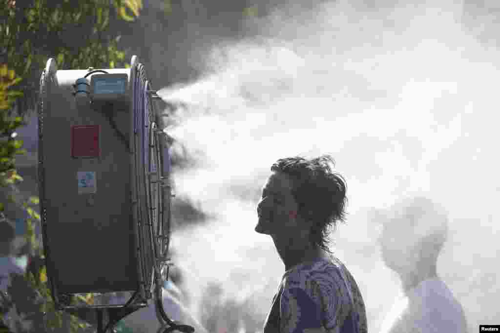 A fan cools down herself at the Australian Open tennis championships in Melbourne.