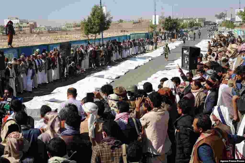 Onlookers gather as Yemenis pray during a mass funeral in Saada for those killed last weekend in airstrikes on a prison in the northern Yemeni province. The attack on the prison in rebel-held Saada, which was blamed on the Saudi-led coalition, left at least 70 people dead and more than 100 were wounded.