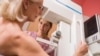 FILE - A nurse assists a patient undergoing a mammogram.