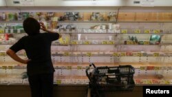 A customer stares at near-empty shelves at a supermarket as people rushed to stock up in preparation for Typhoon Hagibis in Tokyo, Japan, Oct. 11, 2019.
