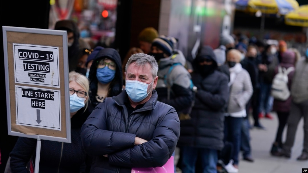 13 Aralık 2021 - New York City'de Times Meydanı'ndaki COVID-19 test merkezi önünde bekleyenler