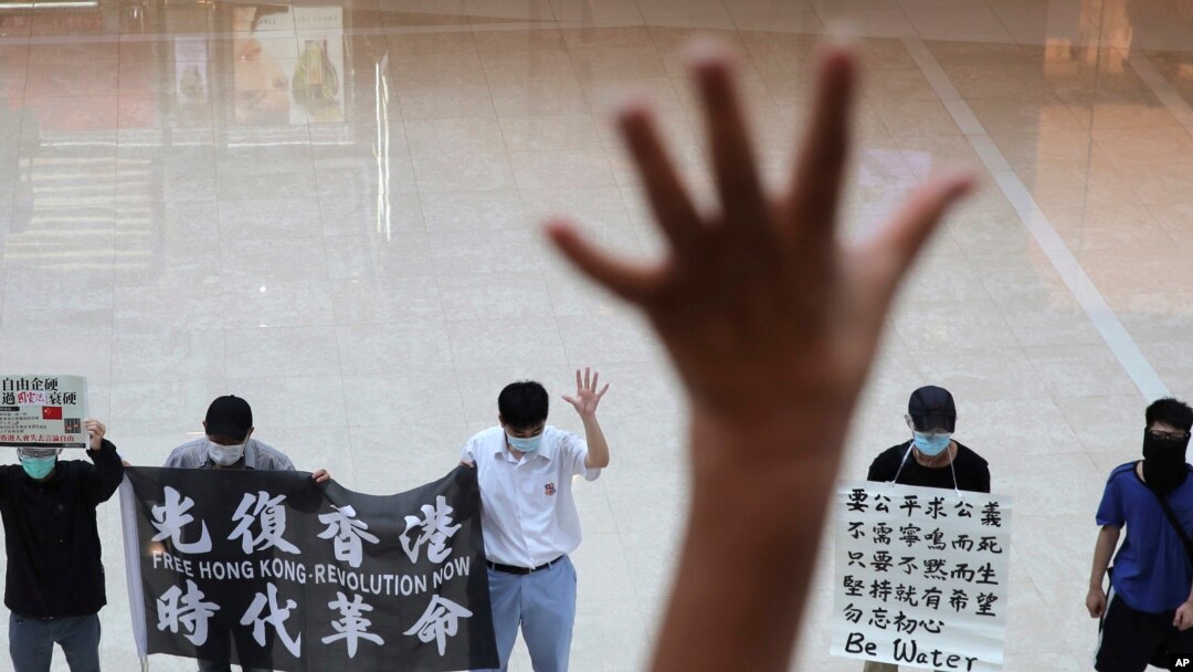 Protesters gesture with five fingers, signifying the "Five demands - not one less" in a shopping mall during a protest against China's national security legislation for the city, in Hong Kong, May 29, 2020.