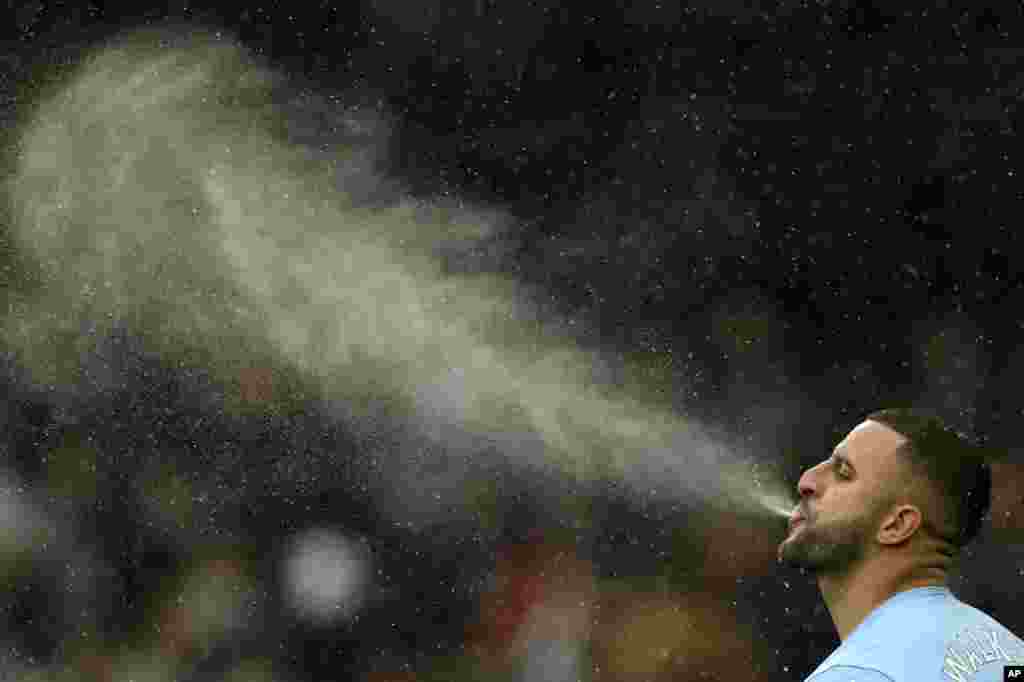 Manchester City's Kyle Walker completes his pre-match ritual of spitting water before the English Premier League soccer match between Manchester City and West Ham United at the Etihad stadium in Manchester, England.