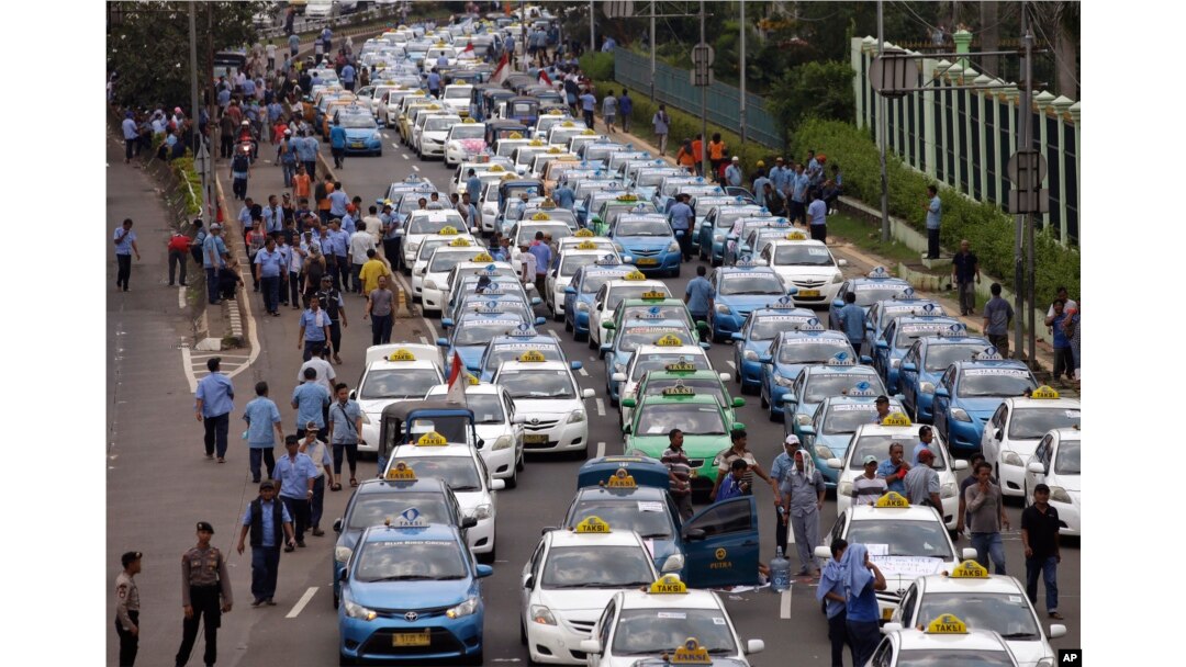 Taxis are lined up during a protest against competition from ride-hailing apps such as Uber and Grab at the main business district in Jakarta, Indonesia, March 22, 2016.