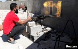 A fighter loyal to Libyan internationally recognized government fires a heavy machine gun during clashes with forces loyal to Khalifa Haftar at outskirts of Tripoli, Libya, May 16, 2019.