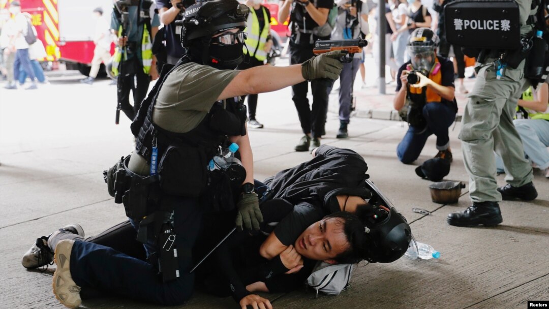 香港警察在逮捕一名參加反對港版國安法遊行示威者的同時舉起手中的胡椒噴劑手槍。（2020年7月1日）