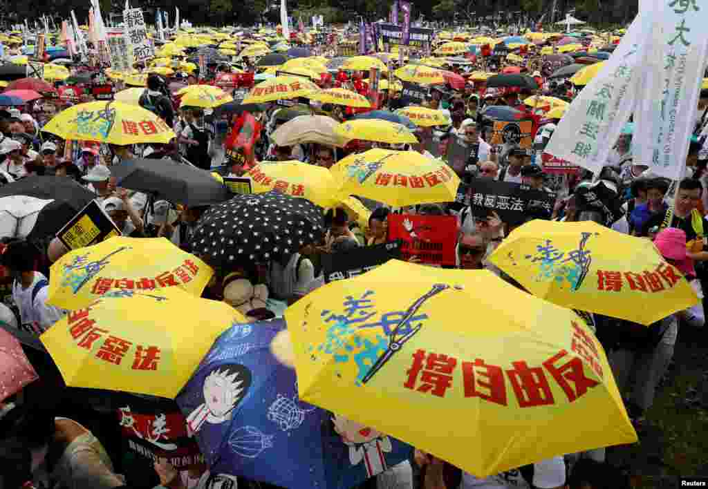 2019年6月9日在中國香港,示威群眾要求當局廢除擬議中的把犯人引渡到中國的法案。他們手持黃色雨傘,這是過去的佔領中環運動的象徵。