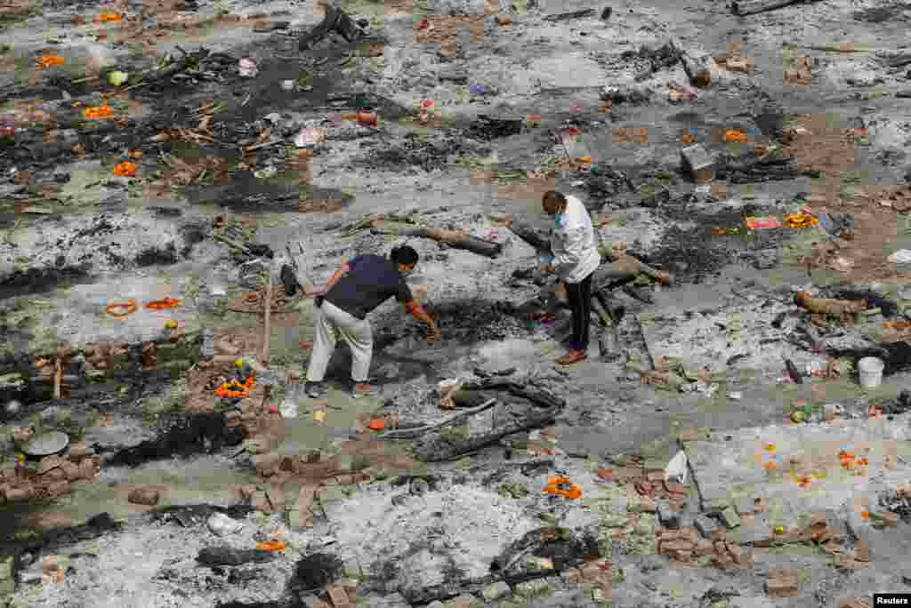 Relatives of a person who died from the coronavirus disease collect ashes at the spot where he was cremated, as part of a ritual at a crematorium in New Delhi, India.