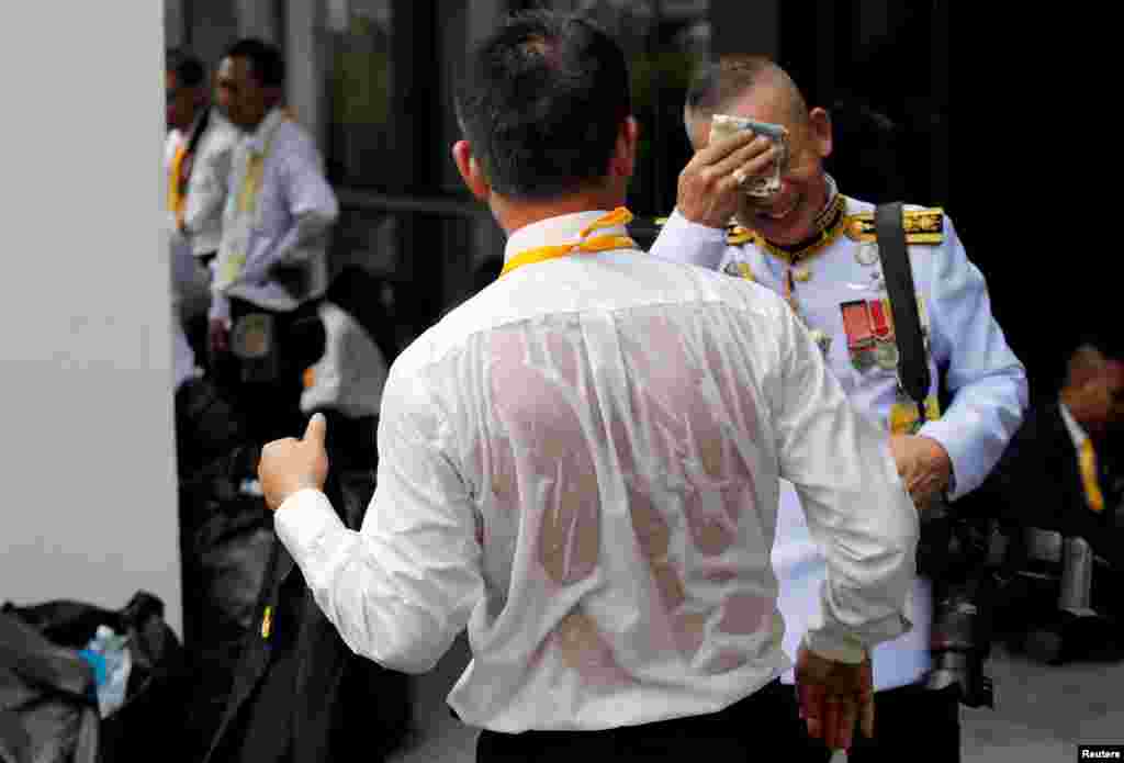 A journalist is seen soaked in sweat as he waits outside the balcony of Suddhaisavarya Prasad Hall at the Grand Palace, where of King Maha Vajiralongkorn will grant a public audience to receive the good wishes of the people in Bangkok, Thailand.