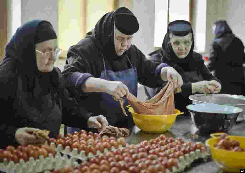 An Orthodox nun handles colored eggs at the Timiseni Monastery, outside Sag, western Romania, April 18, 2014. 