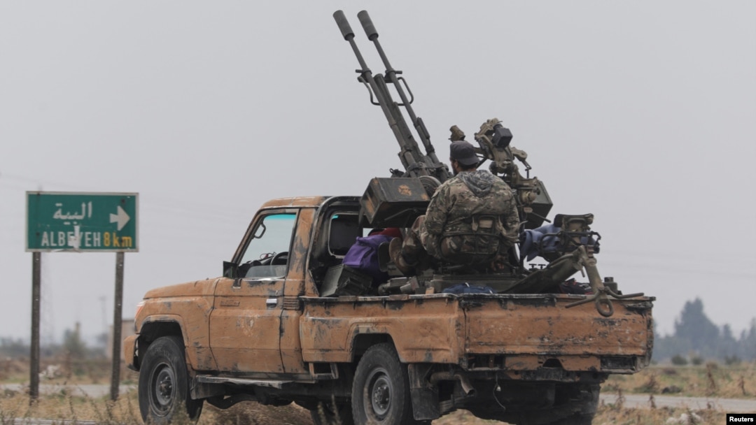 A rebel fighter sits on the back of a vehicle near Homs, Syria, after insurgents pressed their lightning advance on Dec. 7, 2024, saying they had seized most of the south, as government forces dug in to defend the key central city of Homs.