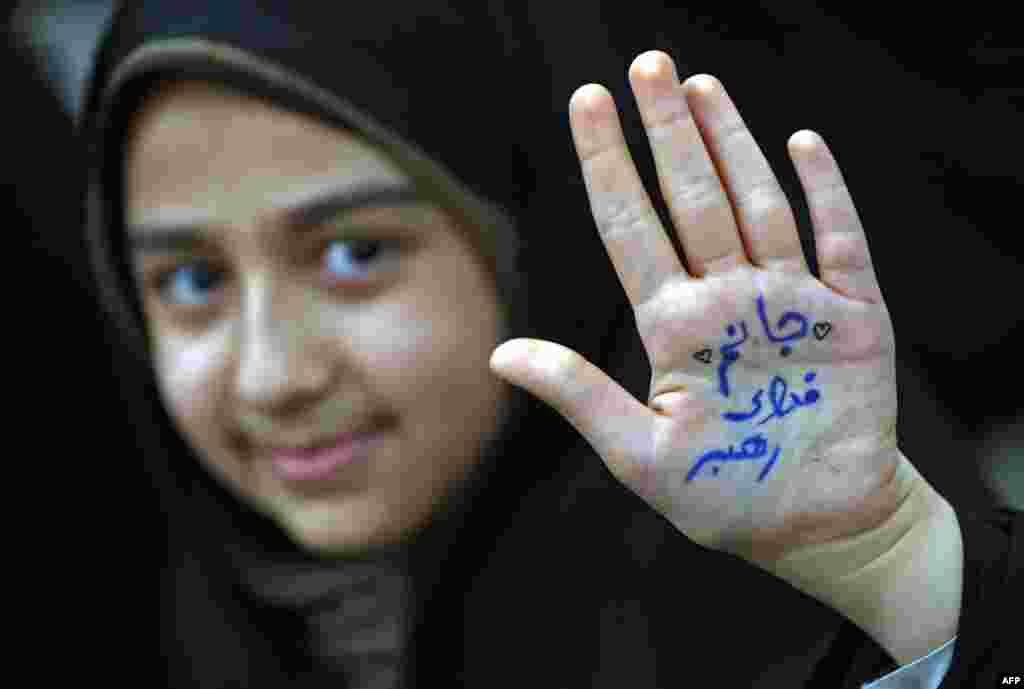 An Iranian girl shows her hand with a slogan reading in Farsi: "Ready to sacrifice my self for the leader" at the tomb of Iran's late founder of the Islamic Republic, Ayatollah Ruhollah Khomeini, on the occasion of 40th anniversary of Khomeini's return from exile from Paris at his mausoleum in southern Tehran.