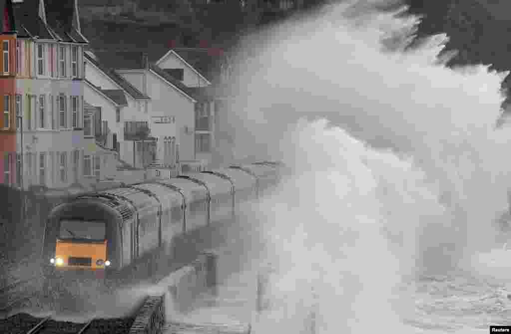 Large waves crash over a train as it passes through Dawlish in southwest Britain.