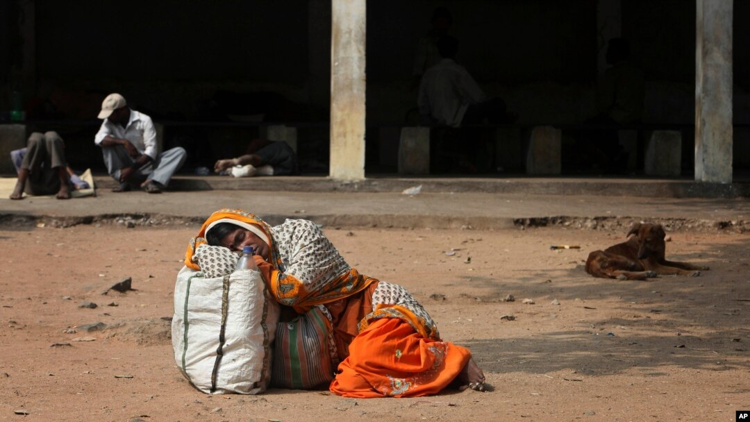 FILE - An Indian attendant of a patient suspected with swine flu virus rests on the ground in the premises of Gandhi Hospital in Hyderabad, India, Wednesday, Jan. 21, 2015. According to local reports, nine people died of the flu at the state-run hospital. 