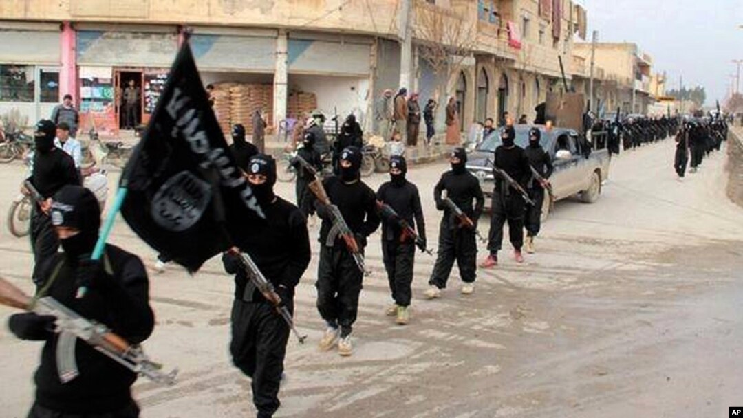Suriyaning Raqqa shahridagi ko'chalardan birida jangarilar namoyishkorona yurish bilan o'tmoqda, 14-yanvar, 2014-yil.