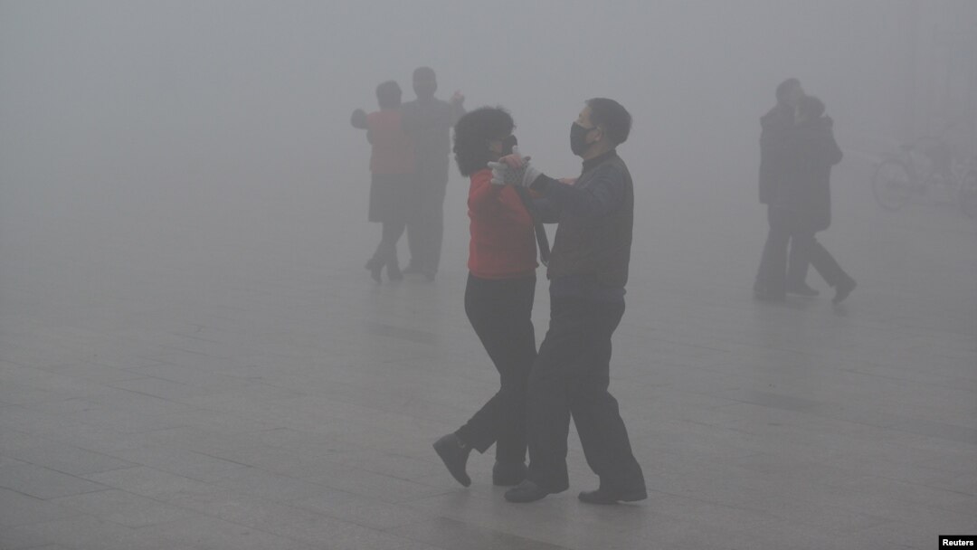People wearing masks dance at a square amid heavy smog during a polluted day in Fuyang, Anhui province, China, Jan. 3, 2017. Fuyang is about 700 miles south of Beijing.