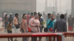 Indian and foreign tourists wear pollution mask and take a walk at the India Gate amidst morning smog in New Delhi, India, Monday, Nov. 4, 2019. (AP Photo/Manish Swarup)