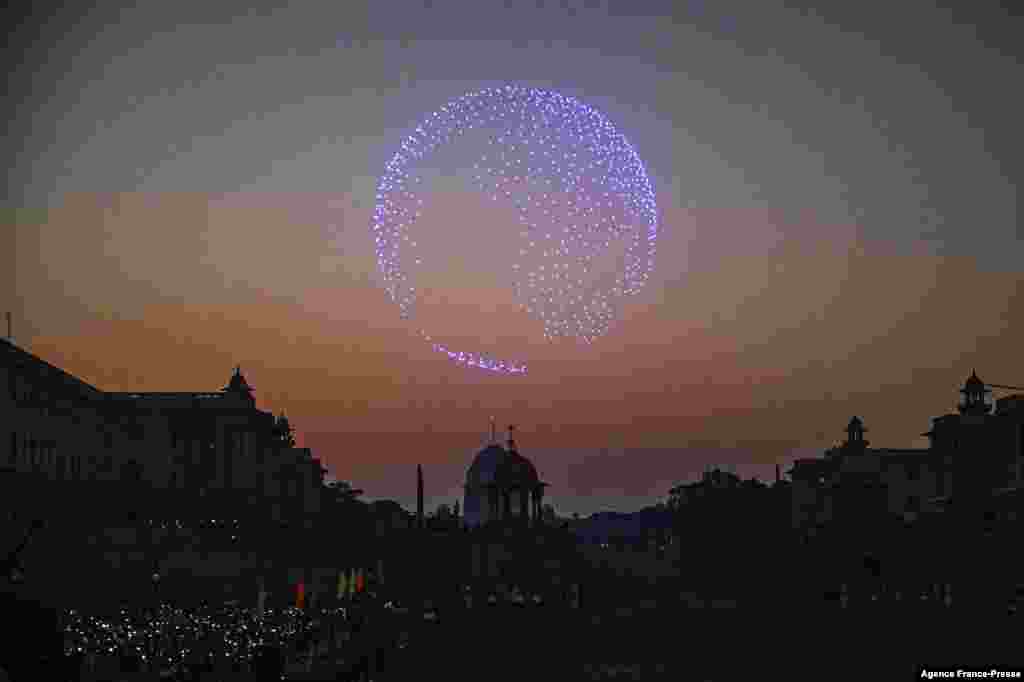 Spectators use their mobile phones as drones with lights fly over the Presidental Palace during the 'Beating Retreat' ceremony in New Delhi, India, Jan. 29, 2022.