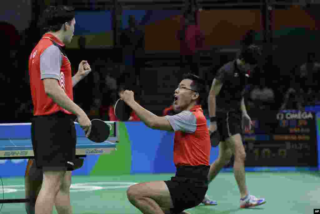 Zeng Yi Wang and reacts Daniel Gorak , left, of Poland celebrate their win against Maharu Yoshimura and Koki Niwa of Japan during their men's team table tennis quarter final match at the 2016 Summer Olympics in Rio de Janeiro, Brazil, Aug. 13, 2016.