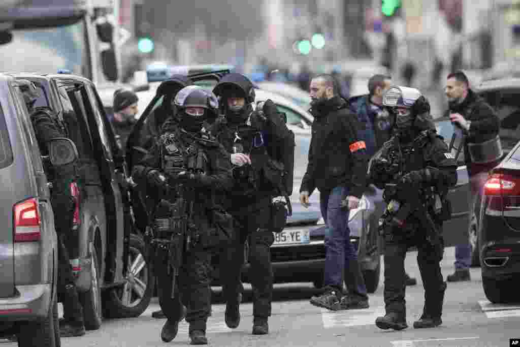 French police forces take position in the Neudorf district of Strasbourg, eastern France. Security forces were trying to catch the suspected Strasbourg gunman dead or alive as the city was still in mourning with candles lit and flowers left at the site of Tuesday's attack near the Christmas market.