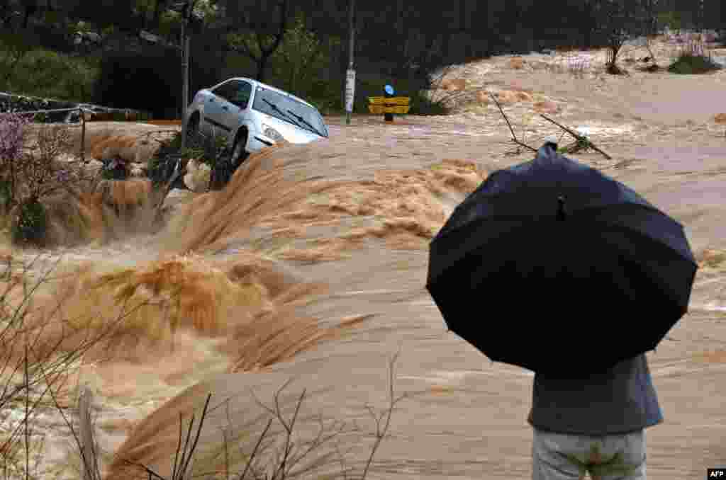 Flash floods caused by torrential rain go down a street on the outskirts of Jerusalem, Israel.