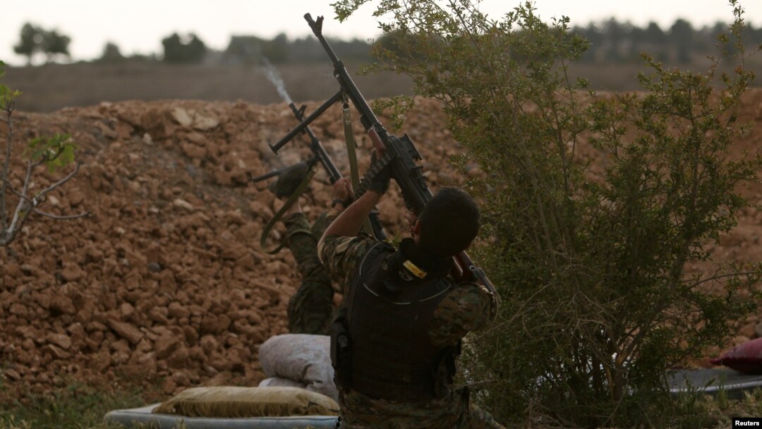 Syrian Democratic Forces (SDF) fighters shoot at a drone they said belonged to Islamic State fighters on the bank of the Euphrates river, west of Raqqa, Syria, April 8, 2017. 