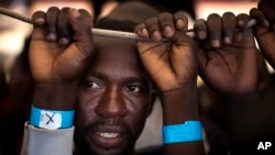 Samuel, 25, from Nigeria, waits his turn to leave the Golfo Azzurro rescue vessel as it arrives at the port of Pozzallo, south of Sicily, Italy, with hundreds of migrants aboard, rescued by members of Proactive Open Arms NGO, June 17, 2017.