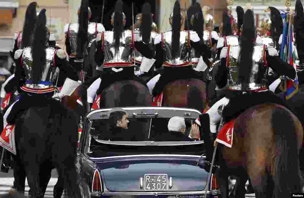 Italy's new President Sergio Mattarella (R) and Prime Mnister Matteo Renzi are escorted by Presidential Guards, after visiting the Unknown Soldier's monument in central Rome.