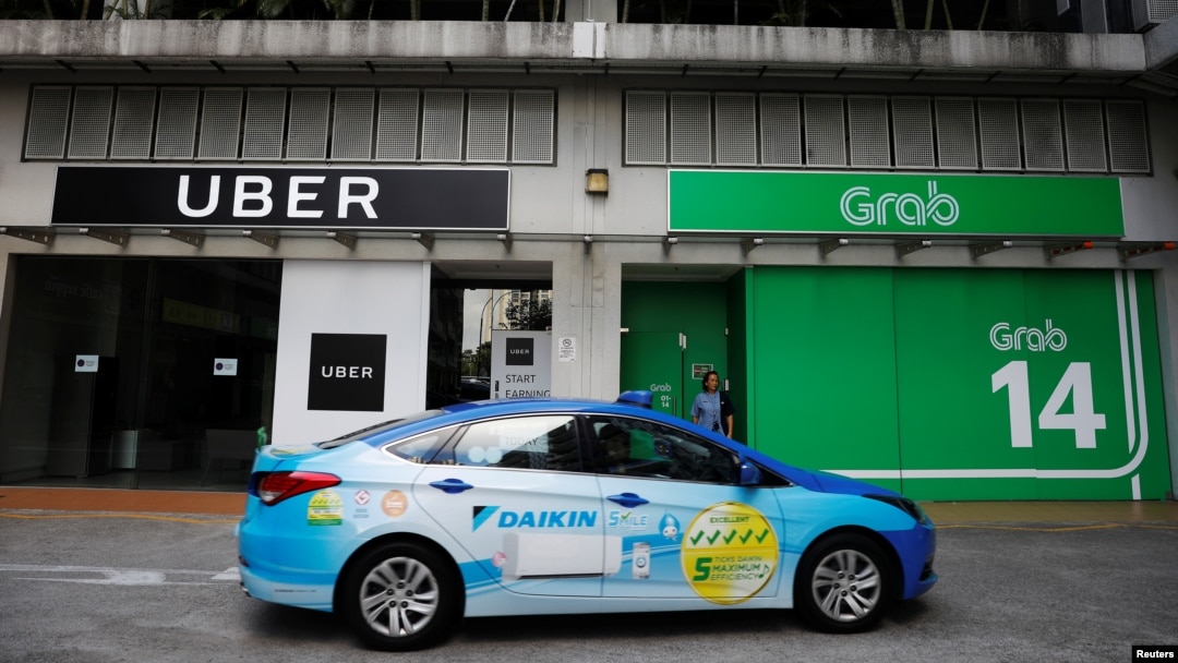 A ComfortDelgro taxi passes Uber and Grab offices in Singapore, March 26, 2018. 