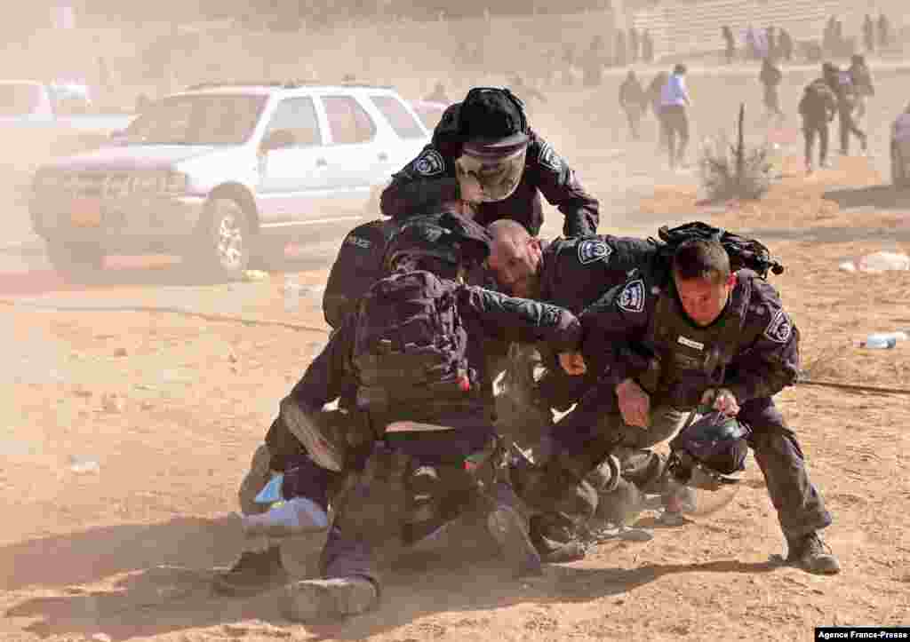 Israeli police detain a man as Bedouins protest an afforestation project by the Jewish National Fund (JNF), in the southern Israeli village of Sa’we al-Atrash in the Neguev Desert .