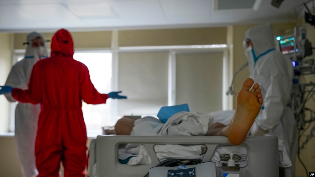 Medics wearing protective suits consult as they treat a COVID-19 patient in intensive care at the Moscow City Clinical Hospital 52, in Moscow, Russia, Oct. 19, 2021.