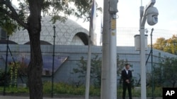 A plainclothes security person stand watch outside the Israeli Embassy in Beijing, Oct. 13, 2023. 