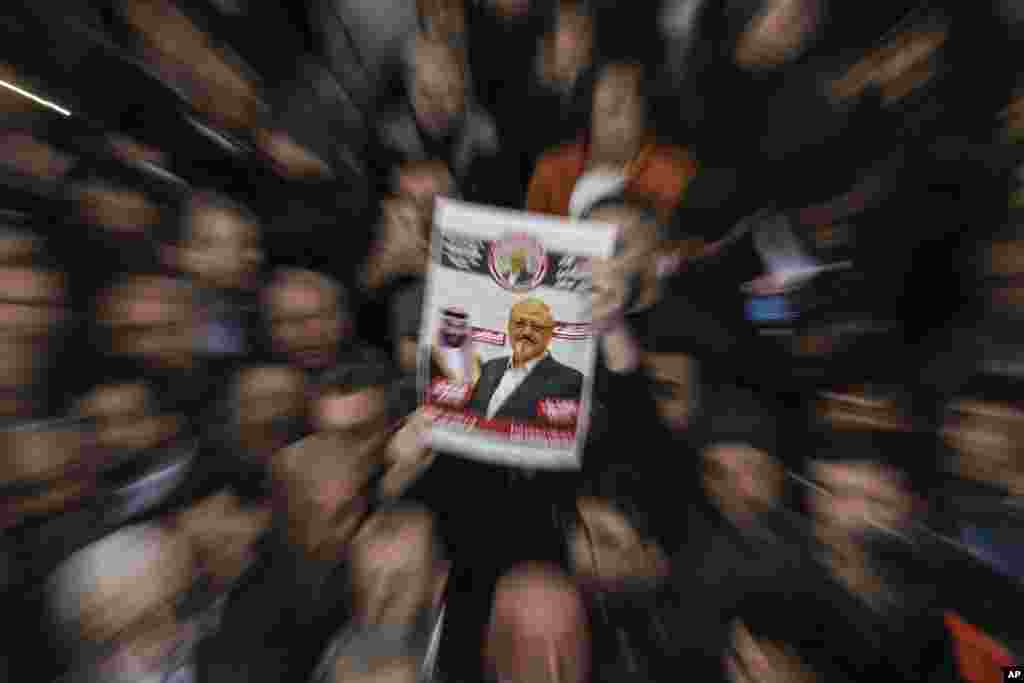 A person holds up a banner as members of the Arab-Turkish Media Association and friends attend funeral prayers in absentia for Saudi writer Jamal Khashoggi who was killed last month in the Saudi Arabia consulate, in Istanbul.