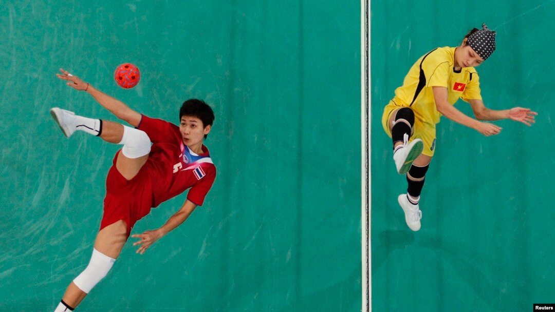 FILE - Thailand's Tidawan Daosakul (red) plays the ball against Vietnam's Nguyen Hai Thiao during their women's sepak takraw regu final at the 2010 Asian Games.