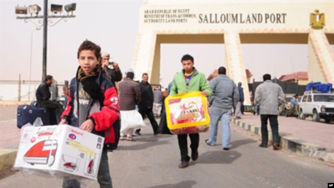 Egyptians return home from the Sallum border crossing with Libya on February 24, 2011
