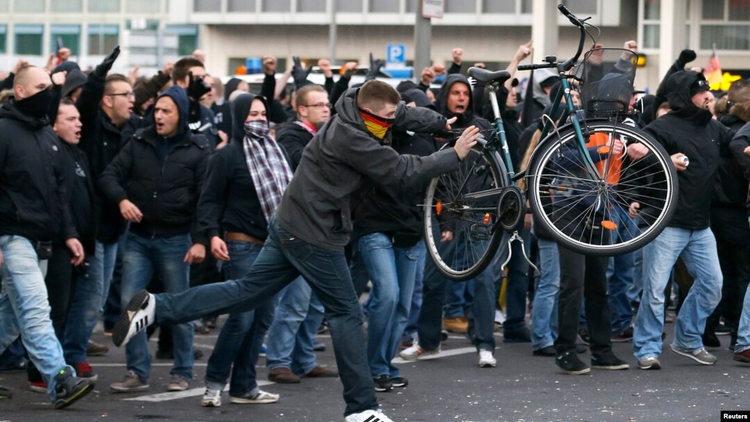 A man throws a bicycle during a demonstration by 'hooligans against Salafists and Islamic State extremist' in Cologne, Germany, Oct. 26, 2014. 