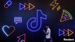 ARCHIVO - Un hombre pasa junto a un cartel de la aplicación TikTok de la compañía china ByteDance, conocida localmente como Douyin, en la Exposición Internacional de Productos Artificiales en Hangzhou, provincia de Zhejiang, China, el 18 de octubre de 2019.