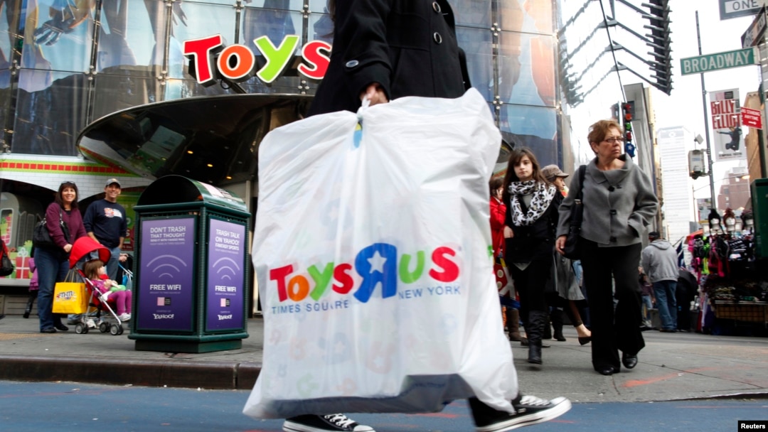 FILE - Shoppers pass by the Toys R Us store at Times Square in New York.