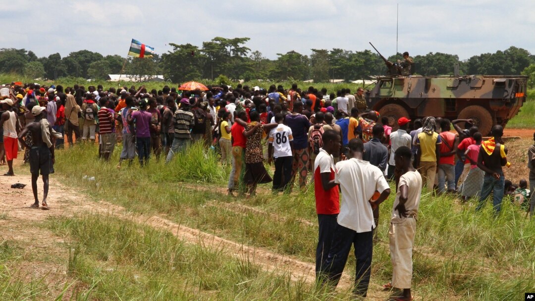 People fleeing ongoing violence gather near a French armored personnel carrier as they seek security at the airport in Bangui, Central African Republic, Aug. 29, 2013.