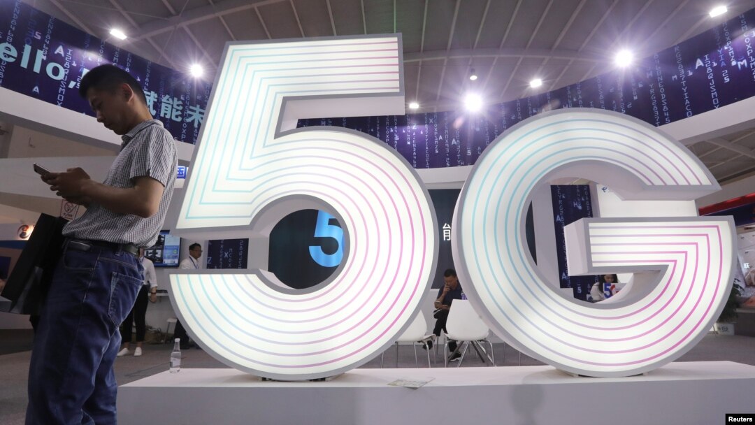 A man stands next to a sign of 5G at the Tencent Global Digital Ecosystem Summit in Kunming, Yunnan province, China, May 23, 2019.