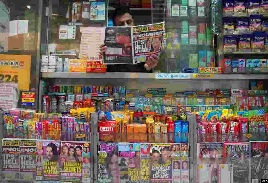 A newspaper vendor on Third Avenue in midtown New York City displays a copy of the National Enquirer for a photographer at his news stand. The publisher of the National Enquirer said Friday it would open an internal probe of accusations by Amazon's Jeff Bezos over blackmail and extortion by the tabloid.