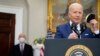 President Joe Biden removes his face mask as he prepares to deliver remarks on the retirement of Supreme Court Associate Justice Stephen Breyer, left, in the Roosevelt Room of the White House in Washington, Jan. 27, 2022. 