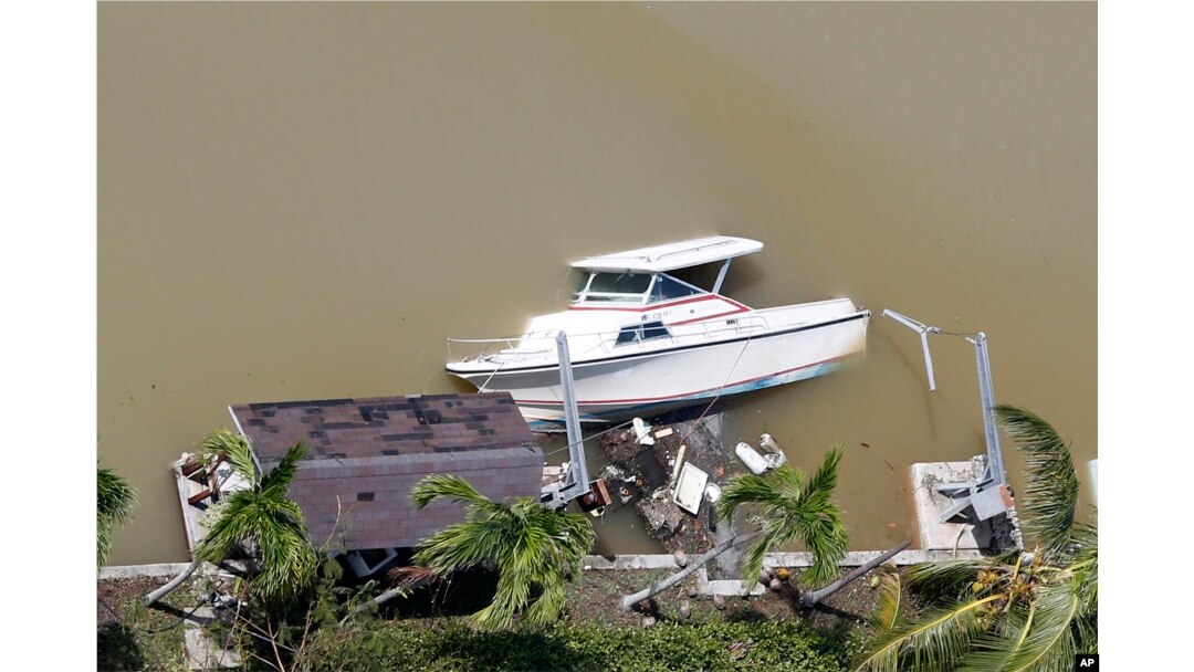 A boat is partially submerged in a canal in the wake of Hurricane Irma, Sept. 11, 2017, in Key Largo, Florida.
