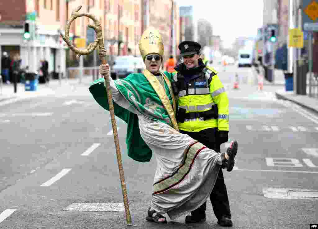 A man dressed as St. Patrick poses with an Irish police officer as participants gather for the annual St. Patrick's Day parade through the city center of Dublin, Ireland, on March 17, 2019.