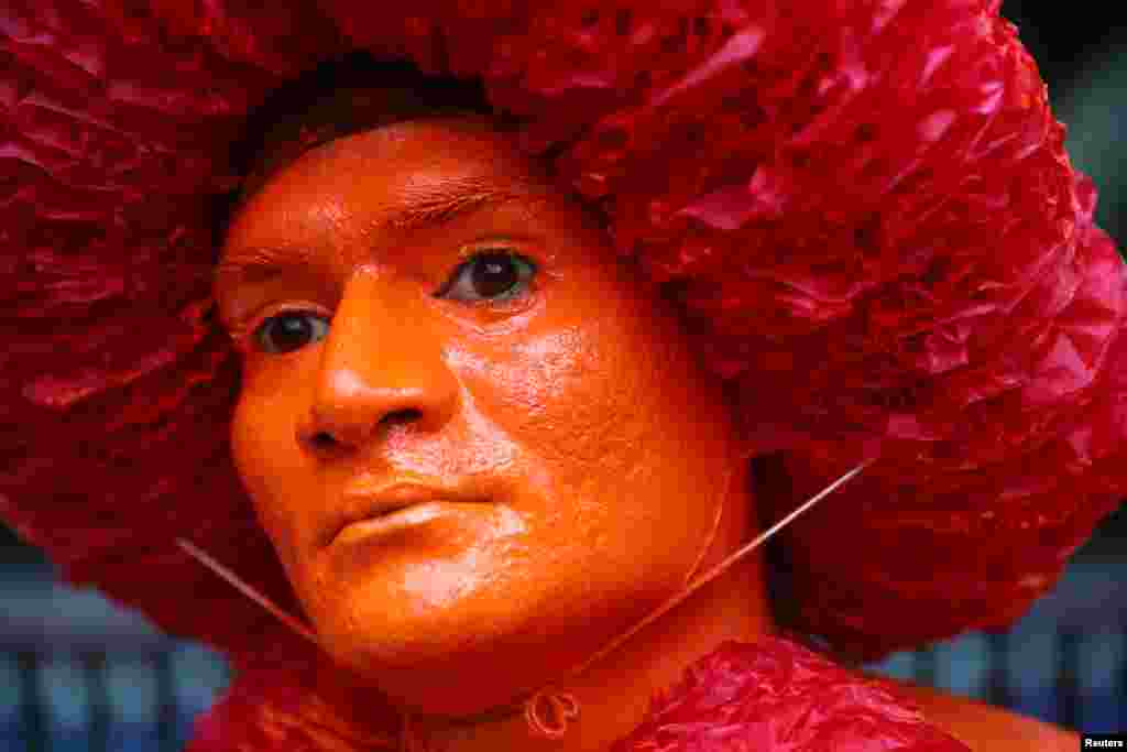 A Hindu devotee displays color applied on his face as he celebrates Lal Kach festival in Munshiganj, Bangladesh, April 13, 2019.