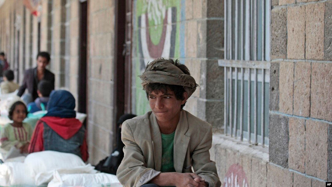 file - A boy waits for food supplies provided by the World Food Program at a school in Sana'a, Yemen, Aug. 25, 2019.