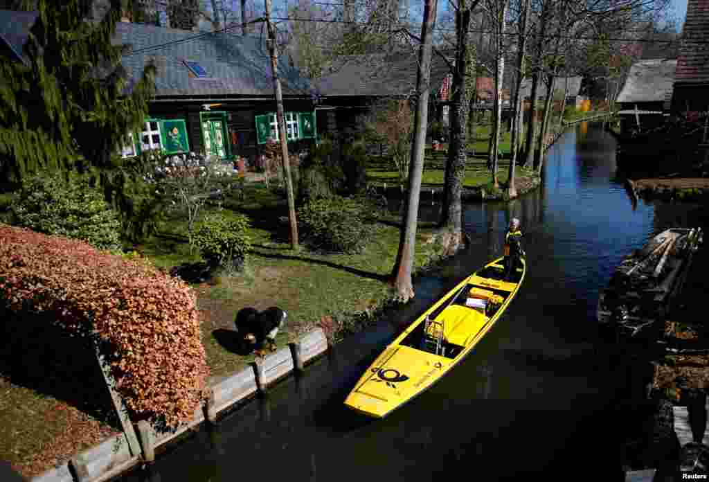 Deutsche Post DHL postwoman Andrea Bunar delivers mail using a traditional boat in the Spreewald village of Lehde, Germany. Bunar is the country's only postwoman to deliver the mail by boat in the village from April until October.