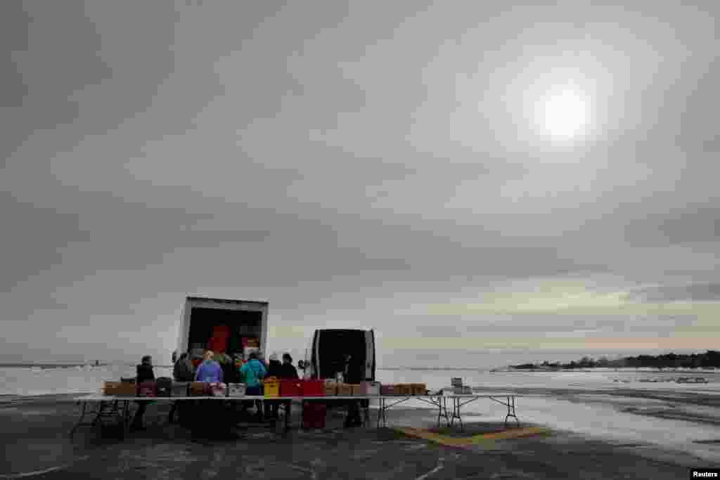 Volunteers and staff of Gather food pantry set up as they prepare to distribute produce, bread, eggs, milk and other supplies to members of the U.S. Coast Guard, who are working without pay during the government shutdown, and their families, at the U.S. Coast Guard Portsmouth Harbor base in New Castle, New Hampshire, Jan. 23, 2019.